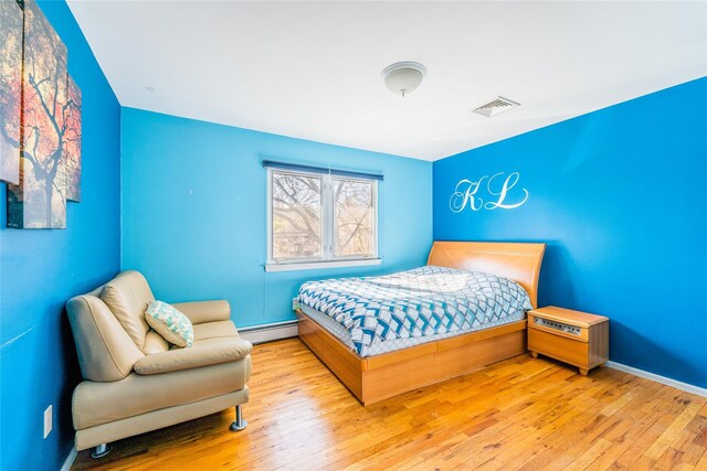 1170 Carlls Straight Path, Dix Hills, NY 11746 - bedroom featuring hardwood / wood-style flooring, baseboards, visible vents, and a baseboard radiator