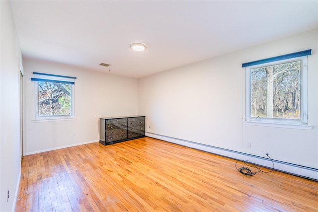 1170 Carlls Straight Path, Dix Hills, NY 11746 - spare room with baseboards, visible vents, a baseboard heating unit, and hardwood / wood-style floors