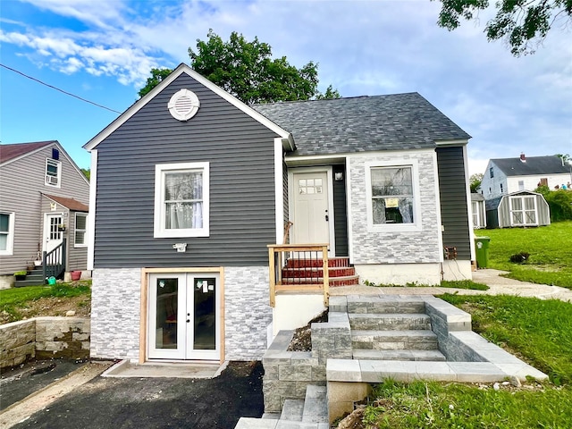 8-10 Mercer St, Middletown, NY 10940 - view of front of house with french doors, a storage unit, stone siding, entry steps, and a shingled roof
