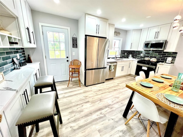 8-10 Mercer St, Middletown, NY 10940 - kitchen with appliances with stainless steel finishes, decorative backsplash, light wood-type flooring, and recessed lighting