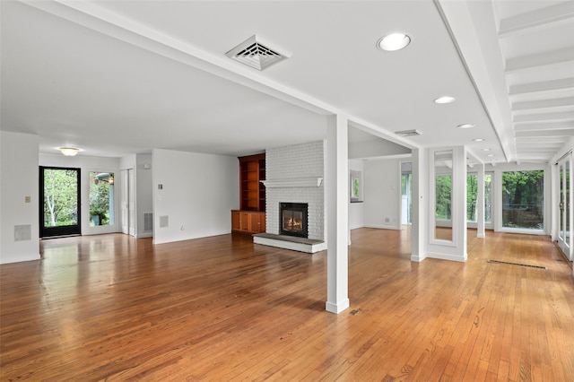 unfurnished living room featuring light wood-type flooring, a fireplace, baseboards, and recessed lighting