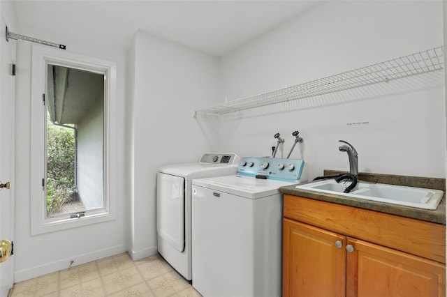 clothes washing area featuring washer and clothes dryer, baseboards, cabinet space, and light floors