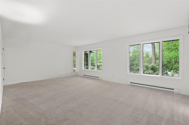 carpeted empty room featuring baseboard heating and baseboards