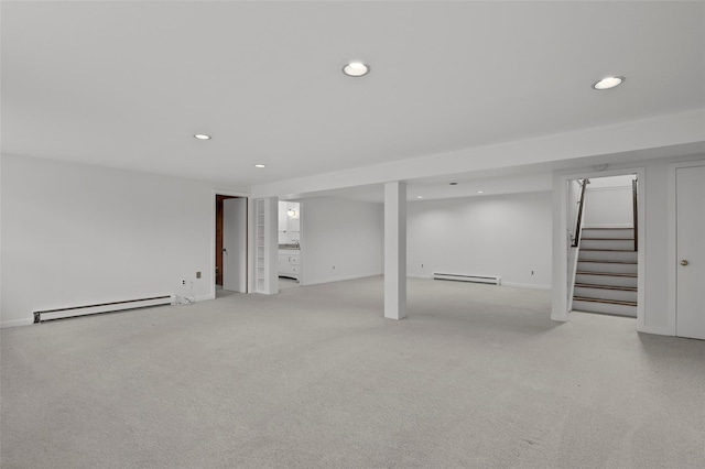 finished basement featuring a baseboard radiator, baseboard heating, stairway, recessed lighting, and baseboards