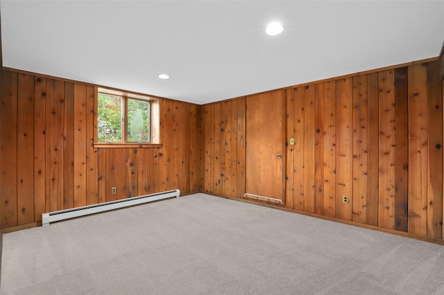spare room featuring a baseboard heating unit, carpet floors, recessed lighting, and wood walls