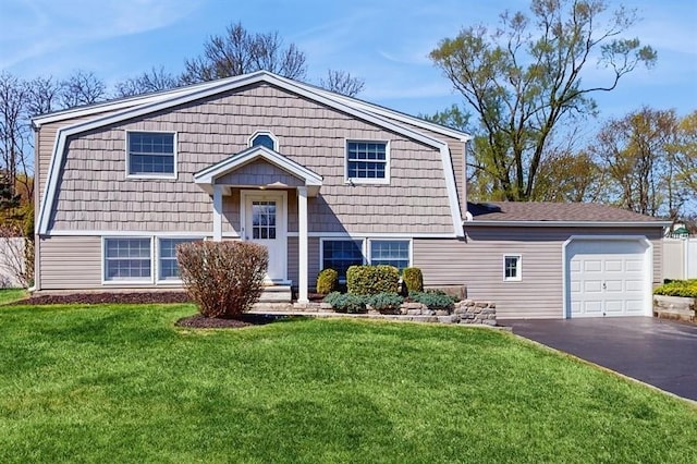 view of front of home with driveway, a gambrel roof, a front lawn, and a garage