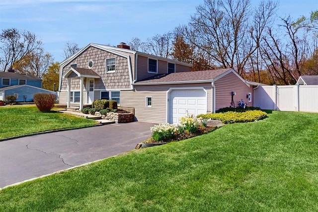 view of front of house featuring a gambrel roof, a chimney, driveway, fence, and a garage