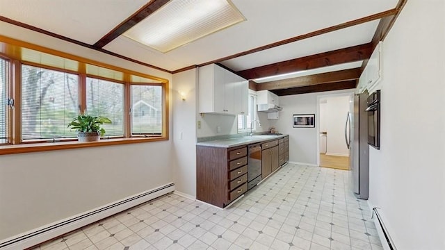 kitchen featuring light countertops, baseboard heating, dishwashing machine, and a wealth of natural light