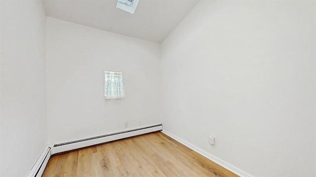 spare room with a baseboard radiator, wood finished floors, lofted ceiling, and baseboards