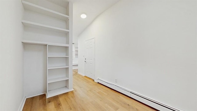 interior space with a baseboard heating unit and light wood-type flooring