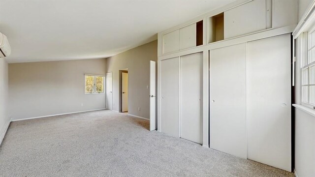 unfurnished bedroom featuring baseboards, multiple closets, and light colored carpet