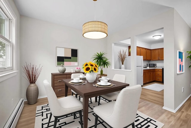 75 Vails Gate Heights Dr, Vails Gate, NY 12553 - dining space featuring a baseboard radiator, light wood-style flooring, and baseboards