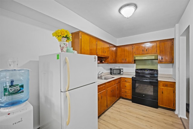 75 Vails Gate Heights Dr, Vails Gate, NY 12553 - kitchen with freestanding refrigerator, black range with electric cooktop, under cabinet range hood, a sink, and stainless steel microwave