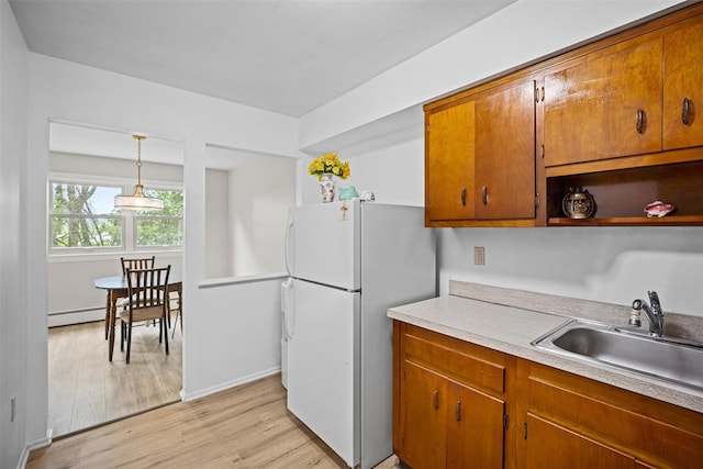 75 Vails Gate Heights Dr, Vails Gate, NY 12553 - kitchen with freestanding refrigerator, a sink, light wood-style floors, light countertops, and a baseboard radiator