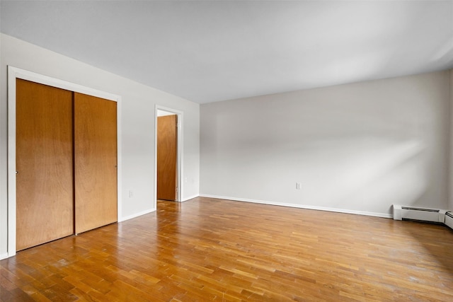 75 Vails Gate Heights Dr, Vails Gate, NY 12553 - unfurnished bedroom with wood finished floors, baseboards, baseboard heating, and a closet