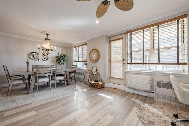 700 Shore Rd Unit 2Z, Long Beach, NY 11561 - dining room featuring baseboards, ornamental molding, wood finished floors, radiator heating unit, and ceiling fan with notable chandelier