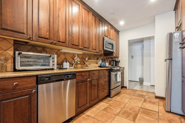 700 Shore Rd Unit 2Z, Long Beach, NY 11561 - kitchen with light tile patterned flooring, a toaster, baseboards, appliances with stainless steel finishes, and backsplash