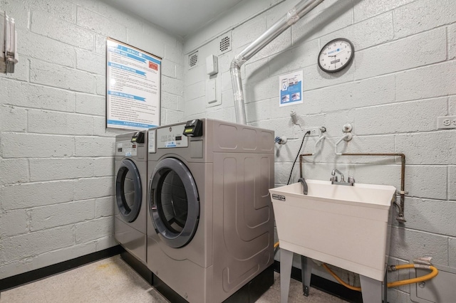 700 Shore Rd Unit 2Z, Long Beach, NY 11561 - washroom with washing machine and clothes dryer, concrete block wall, and a sink