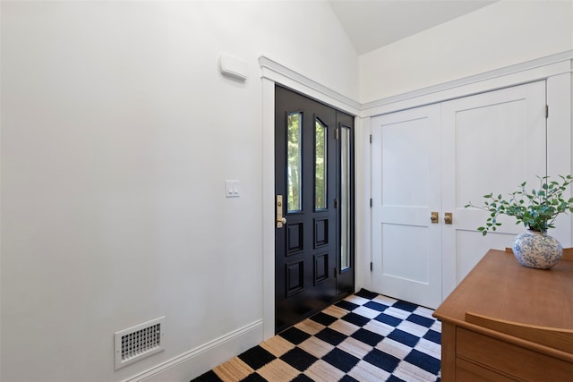 entrance foyer featuring vaulted ceiling and baseboards