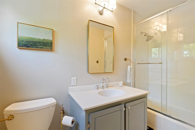full bathroom with toilet, vanity, and bath / shower combo with glass door