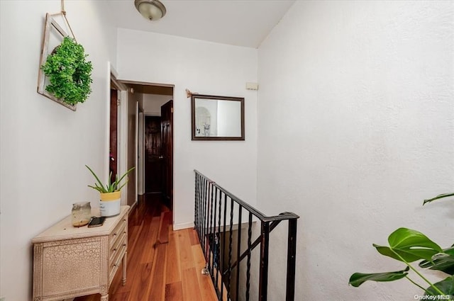 hallway with an upstairs landing and light wood finished floors
