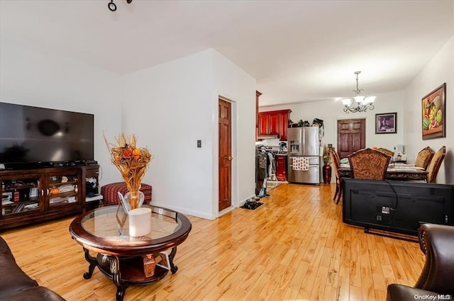 living room featuring light wood-type flooring and a notable chandelier