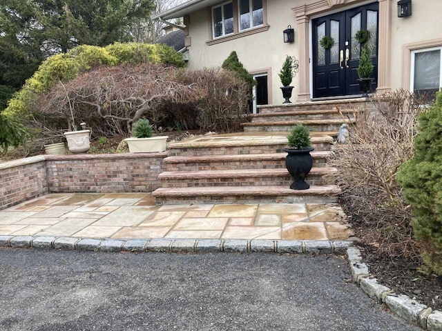 entrance to property with french doors and stucco siding