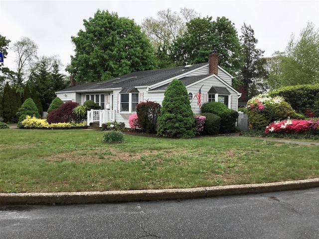 view of side of property with a chimney and a lawn