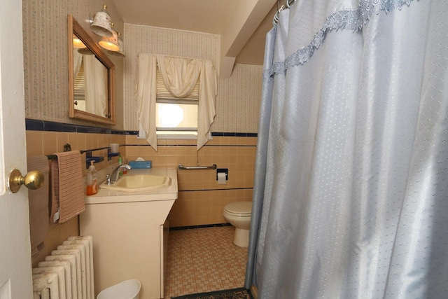 22 Primrose Dr, New Hyde Park, NY 11040 - full bathroom with radiator, toilet, vanity, wallpapered walls, and tile walls