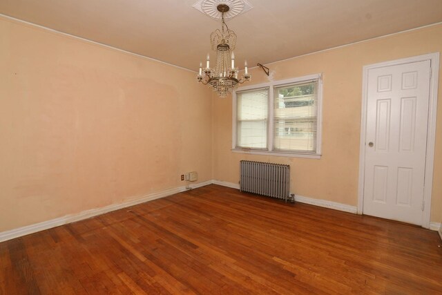 22 Primrose Dr, New Hyde Park, NY 11040 - empty room with radiator, a chandelier, wood finished floors, and baseboards