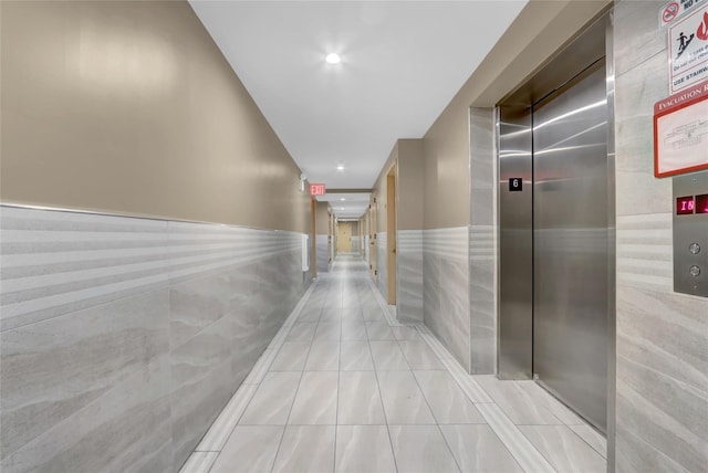 45-16 83rd St Unit E2J, Elmhurst, NY 11373 - hall with elevator, light tile patterned floors, recessed lighting, a wainscoted wall, and tile walls