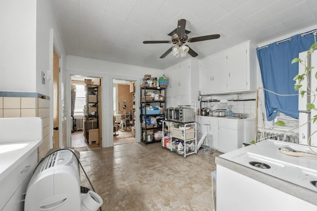 6107 Grand Ave, Maspeth, NY 11378 - kitchen with a ceiling fan, white cabinets, radiator heating unit, light countertops, and stainless steel microwave