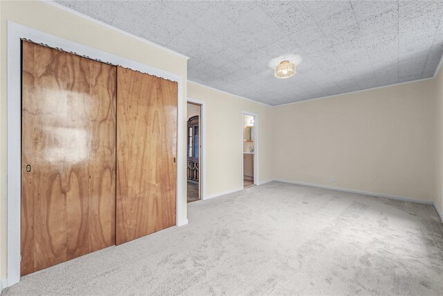 6107 Grand Ave, Maspeth, NY 11378 - unfurnished bedroom featuring carpet flooring, ornamental molding, a closet, baseboards, and connected bathroom