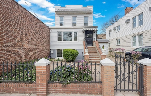 6107 Grand Ave, Maspeth, NY 11378 - view of front of house with a fenced front yard, a gate, and an AC wall unit