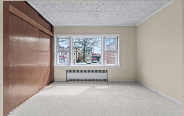6107 Grand Ave, Maspeth, NY 11378 - spare room with radiator, light carpet, crown molding, and baseboards