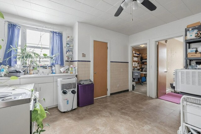 6107 Grand Ave, Maspeth, NY 11378 - kitchen with white cabinets, a ceiling fan, light countertops, stove, and a wainscoted wall
