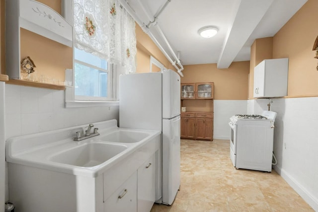 6107 Grand Ave, Maspeth, NY 11378 - kitchen featuring white appliances, light countertops, and a wainscoted wall