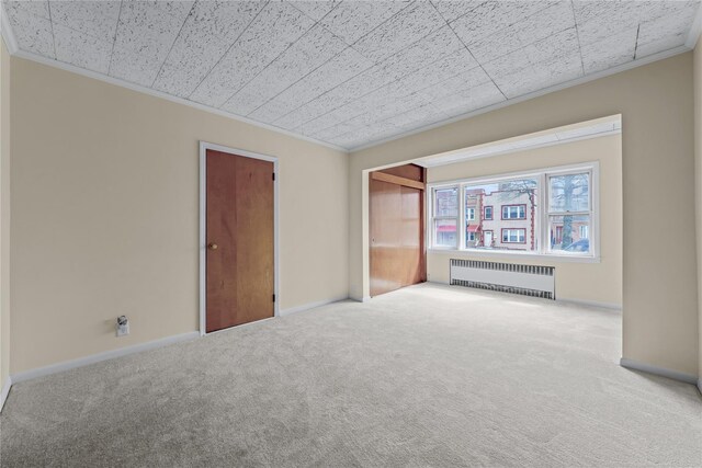 6107 Grand Ave, Maspeth, NY 11378 - unfurnished bedroom featuring radiator, crown molding, carpet, baseboards, and a closet