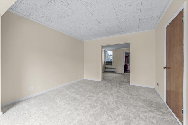 6107 Grand Ave, Maspeth, NY 11378 - empty room featuring radiator, light carpet, crown molding, and baseboards