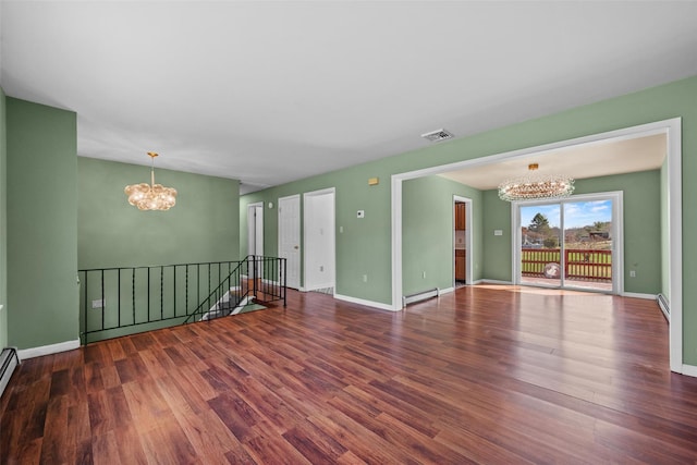 empty room with baseboards, a notable chandelier, and wood finished floors