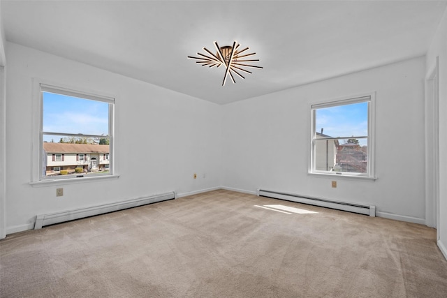 spare room with carpet flooring, a wealth of natural light, and a baseboard heating unit
