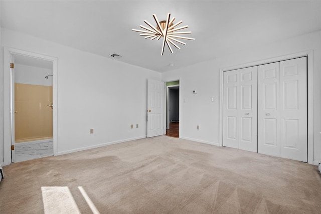 unfurnished bedroom with carpet floors, baseboards, ensuite bathroom, and visible vents