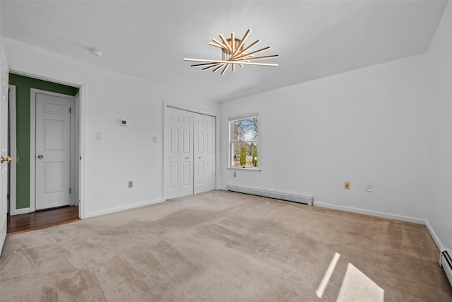 unfurnished bedroom featuring carpet, baseboards, and a baseboard heating unit