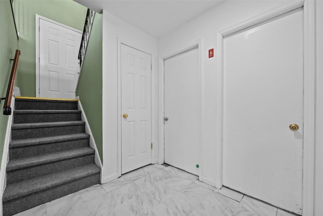 stairs featuring marble finish floor and baseboards