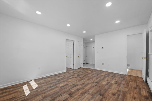unfurnished room featuring wood finished floors, baseboards, and recessed lighting
