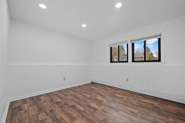 empty room featuring baseboards, baseboard heating, wood finished floors, and recessed lighting