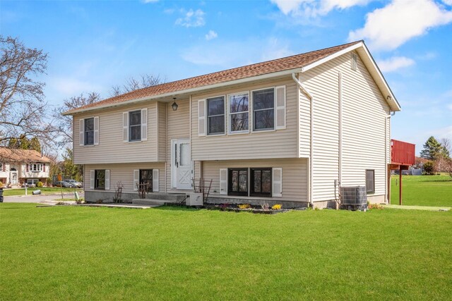 back of house with a lawn and central AC