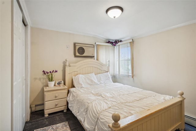 bedroom featuring dark carpet, a baseboard heating unit, a closet, and ornamental molding