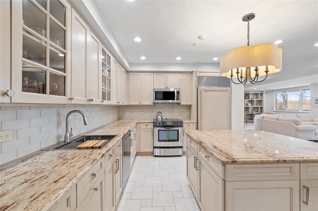 100 Harbor View Dr Unit 230, Port Washington, NY 11050 - kitchen with stainless steel appliances, decorative backsplash, light stone countertops, a chandelier, and open floor plan