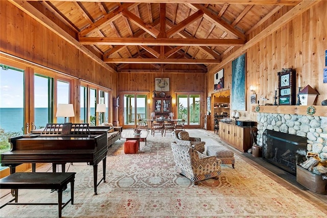 1635 Isabella Beach Rd, Fishers Island, NY 06390 - living area with wooden walls, high vaulted ceiling, wood ceiling with exposed beams, a fireplace, and a water view